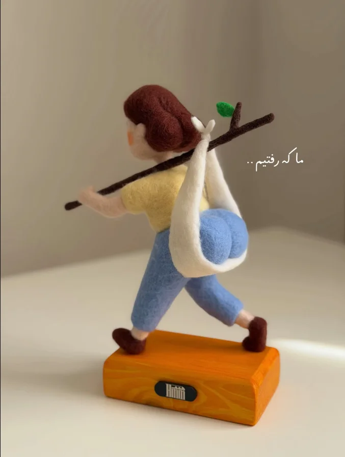 Fine. I'll Just Take My Things And Leave — Felted wool figurine of woman walking with butt-shaped bindle on stick, with Farsi caption