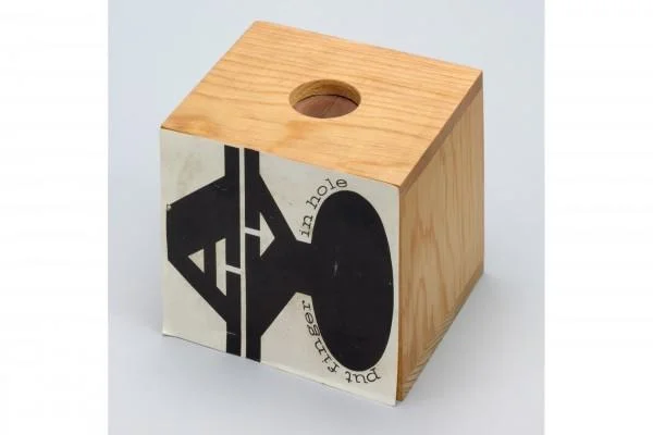 Finger Boxes — Wooden cube fingerbox with hole and label reading 'put finger in hole'.