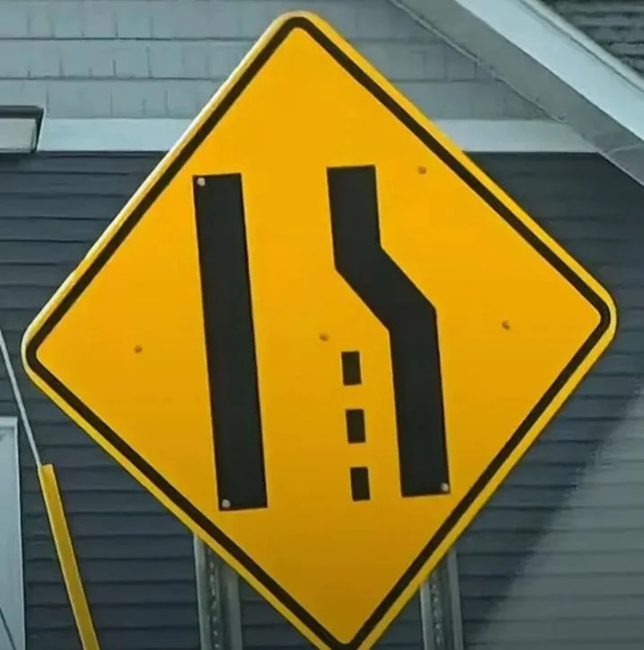 Yellow road sign with lane merge symbols resembling Flight Pattern Recognition meme