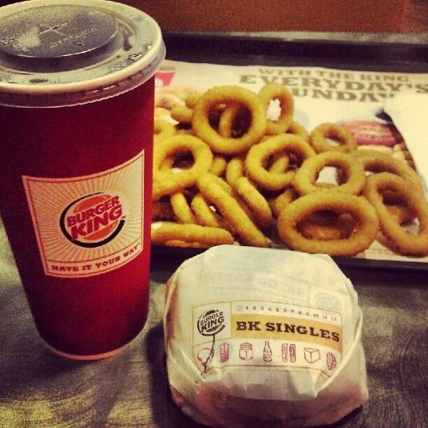 Food Porn — Moody Instagram-style photo of Burger King drink, onion rings, burger.