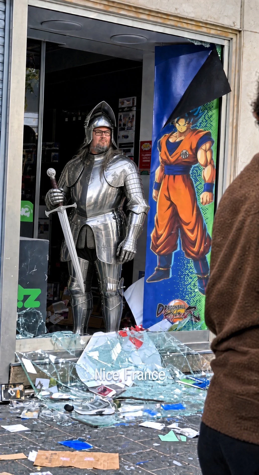 French Goku Hero photoshop: Pierre edited to wear medieval knight armor while standing at the Micromania entrance.
