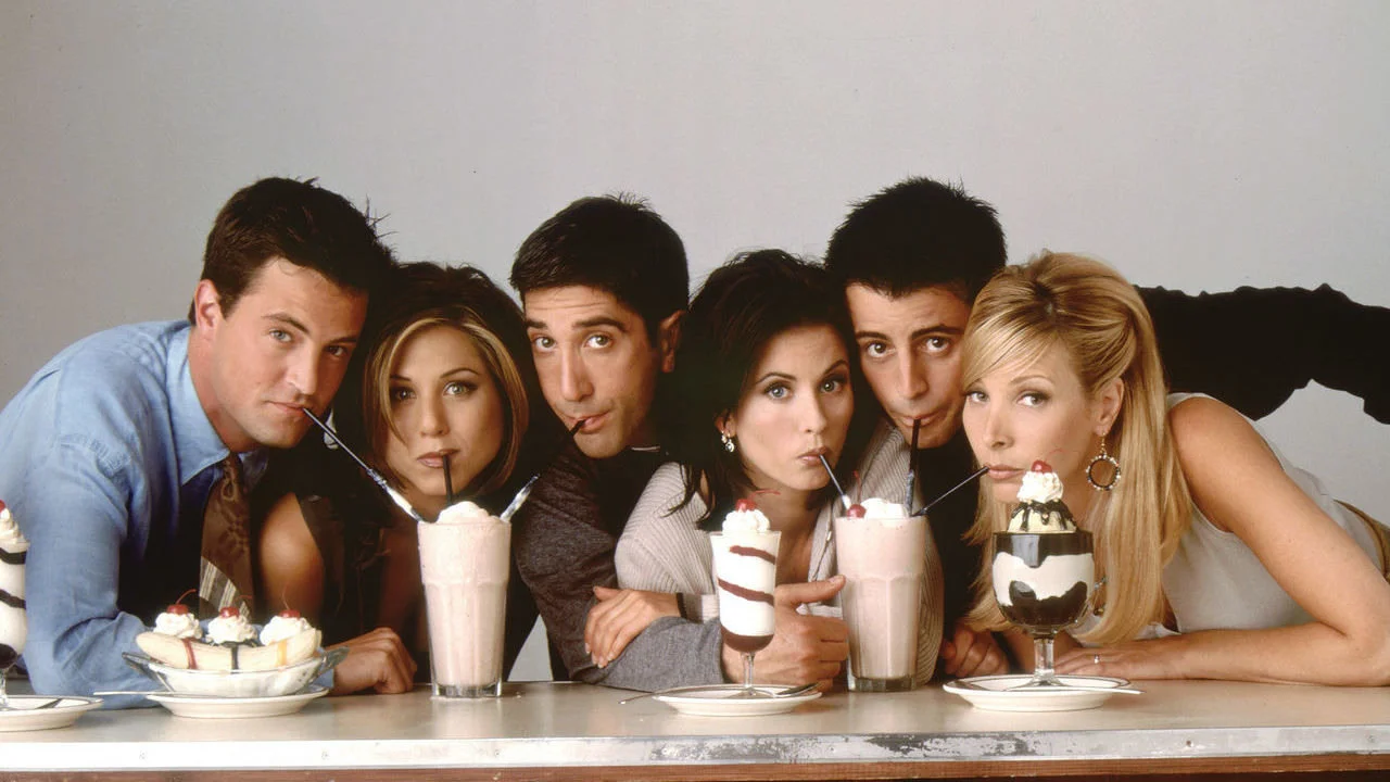 Friends cast Chandler, Rachel, Ross, Monica, Joey and Phoebe drinking milkshakes at a diner counter