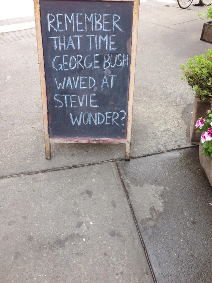 Funny Store Signs — Chalkboard sidewalk sign reading 'Remember that time George Bush waved at Stevie Wonder?'
