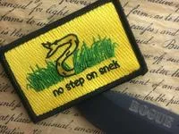 Gadsden Flag Dont Tread On Me — A photograph of a yellow shirt or wearable item with the Gadsden Flag design featuring a coiled snake and text printed on