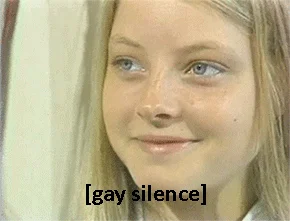 Gay Silence — A blonde woman with a serene, subtle smile expressing composed silence in response to awkward topics.
