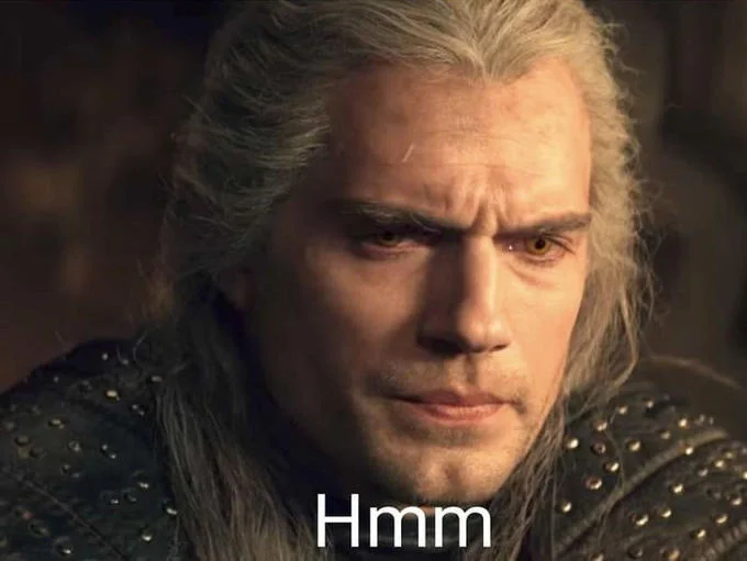 Geralts Hmm — The classic reaction image of Henry Cavill as Geralt with signature contemplative expression and 'Hmm' subtitle.