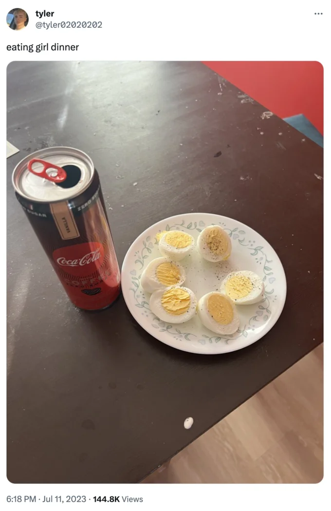Girl Dinner — A Twitter post showing boiled eggs on white plate paired with Coca-Cola bottle exemplifying minimal-effort meal.