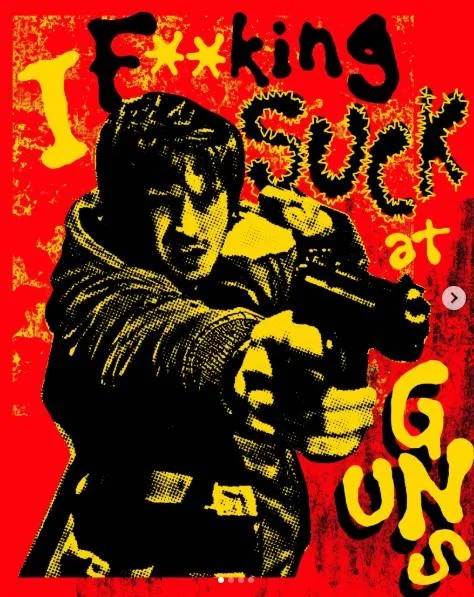 God Damn It, I Fucking Suck At Guns — Red and yellow pop-art style poster of a man aiming a pistol with the text 'I F**king Suck at Guns' overlaid.