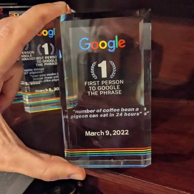 Google First Search Award — Google crystal award engraved 'number of coffee beans a pigeon can eat in 24 hours,' March 9, 2022.