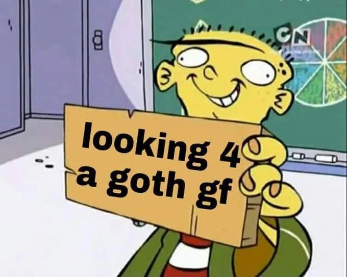 Cartoon character Ed holding a sign reading 'looking 4 a goth gf'.