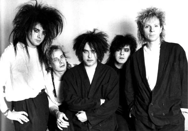 Goth — Black-and-white group portrait of The Cure with teased hair and dark attire.