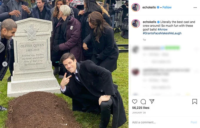 Grant Gustin Next To Oliver Queens Grave — Instagram screenshot of Grant Gustin posing with peace sign beside Oliver Queen's gravestone.