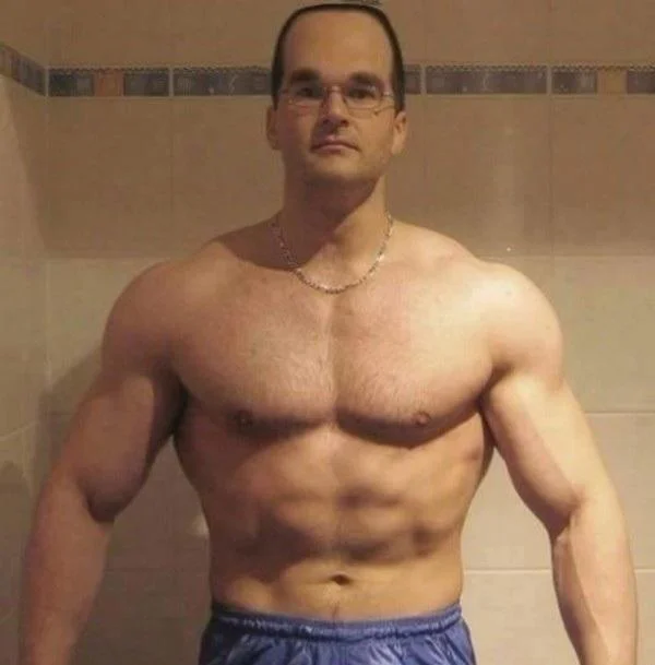 Gymcel — Bathroom mirror selfie of shirtless muscular man displaying physique.