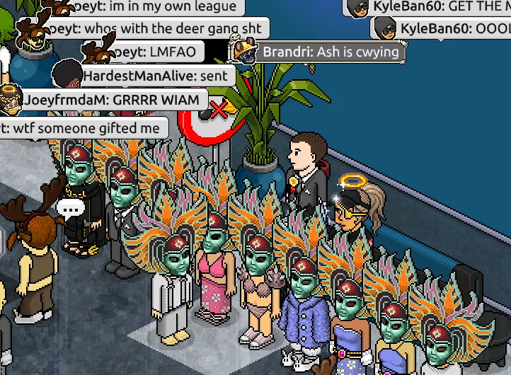 Habbo Hotel room scene with multiple avatars gathered around decorative items with overlaid chat messages.