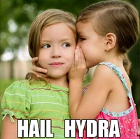 A candid photograph of two young girls outdoors, one leaning in to whisper into the other's ear, with bold 'HAIL HYDRA' text overlaid.