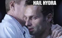 A still from a live-action TV series showing two male characters in an intense face-to-face moment with 'HAIL HYDRA' text overlaid.