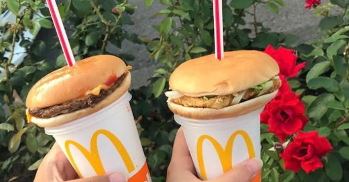 Hamburger Straws — Two McDonald's cups with burgers on top and straws stuck through the buns, held in front of red roses