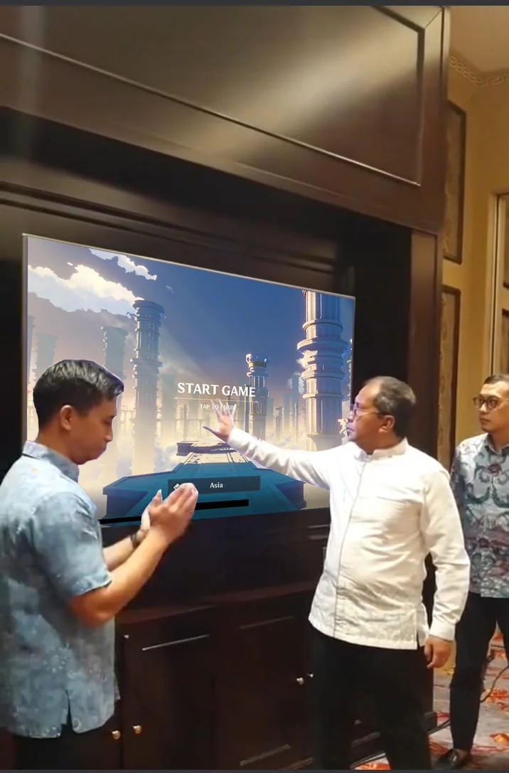 Hand Scanner Video Fail — Man gesturing at a TV screen showing a Start Game menu with ancient architecture