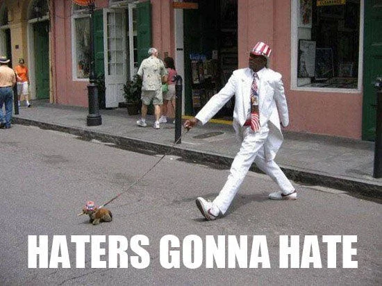 Haters Gonna Hate — Man in white suit walking small dog in matching hat on street