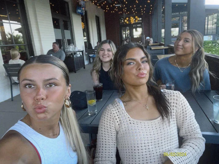 Hawk Tuah Girl — Selfie of Hailey Welch and three friends at an outdoor restaurant patio