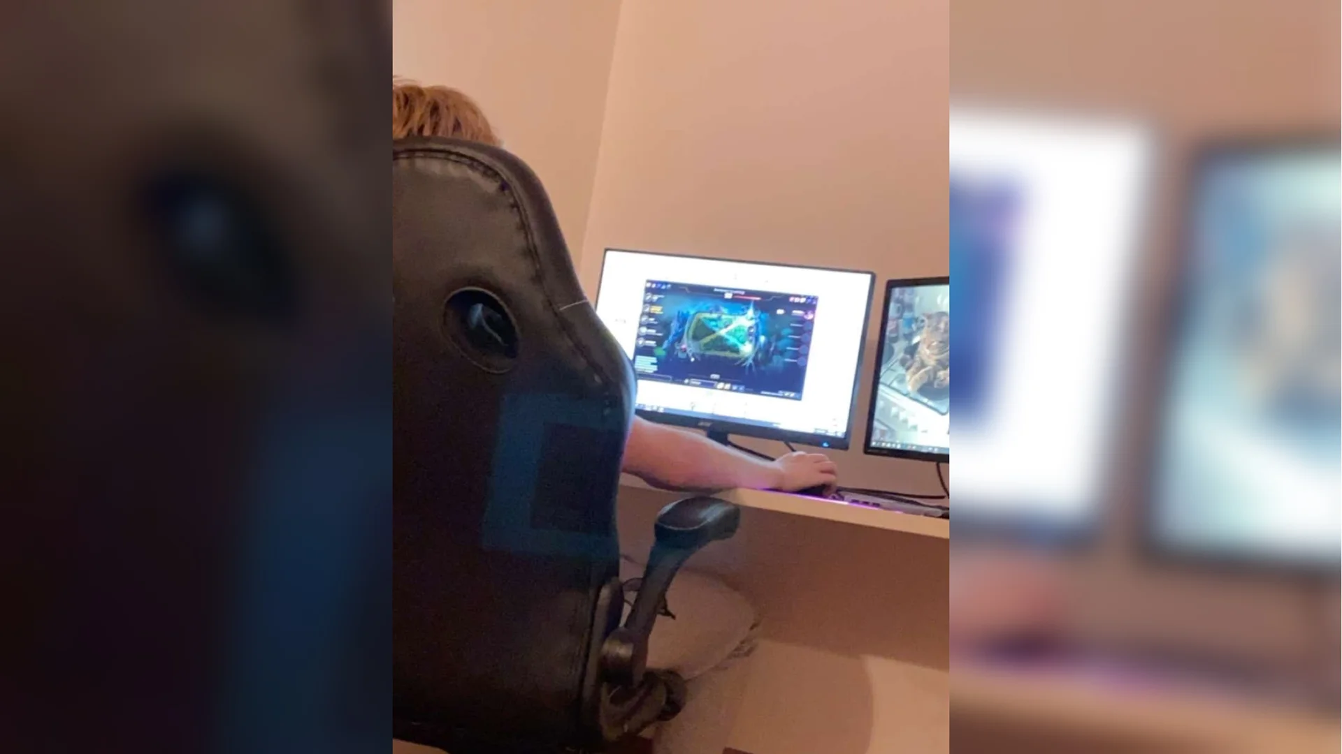 He Literally Just Nutted in Me — Person in gaming chair at desk facing dual monitors with a video game on the main screen