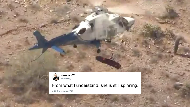 Helicopter Lady Rescue — Helicopter hovering over desert with spinning rescue line and tweet overlay reading 'From what I understand, she is still spinning'