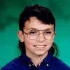 Hello My Future Girlfriend — A close-up crop of Mike Blount's school portrait showing his face and large wire-framed glasses against a green studio background.