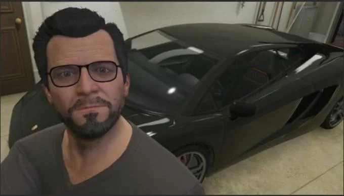 Here In My Garage — A man with glasses and goatee poses in front of a black sports car in a residential garage.