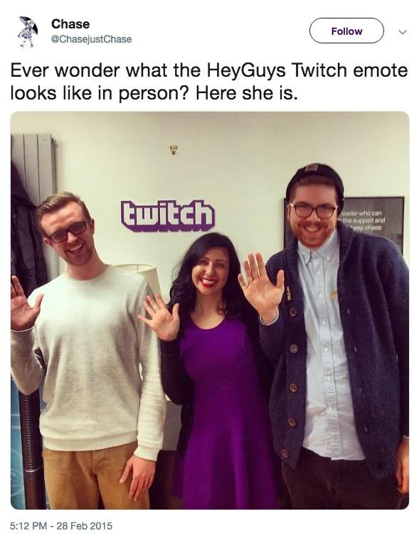 Tweet showing the HeyGuys emote woman in a purple dress waving beside two men at Twitch office