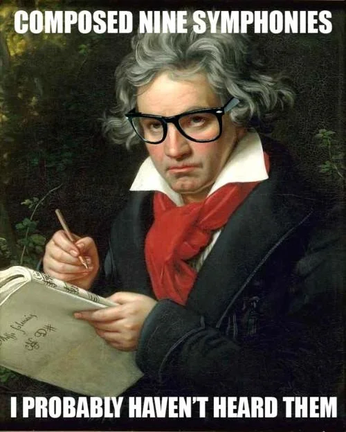 Historical figure in formal period dress now wearing black thick-framed hipster glasses with composition caption.