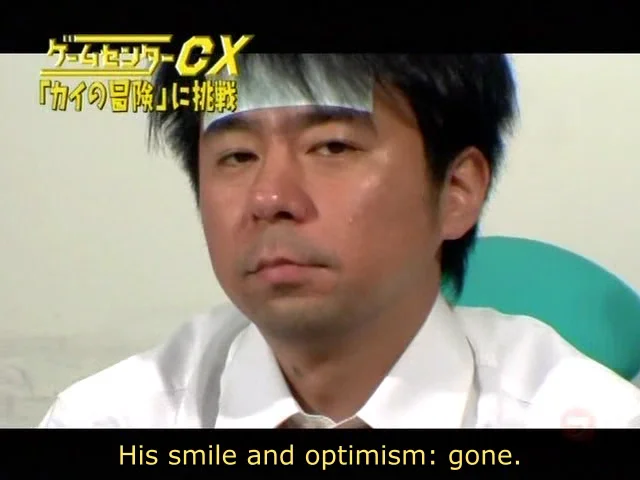 Wider screenshot of Shinya Arino on Game Center CX with the show's logo and the subtitle 'His smile and optimism: gone.'
