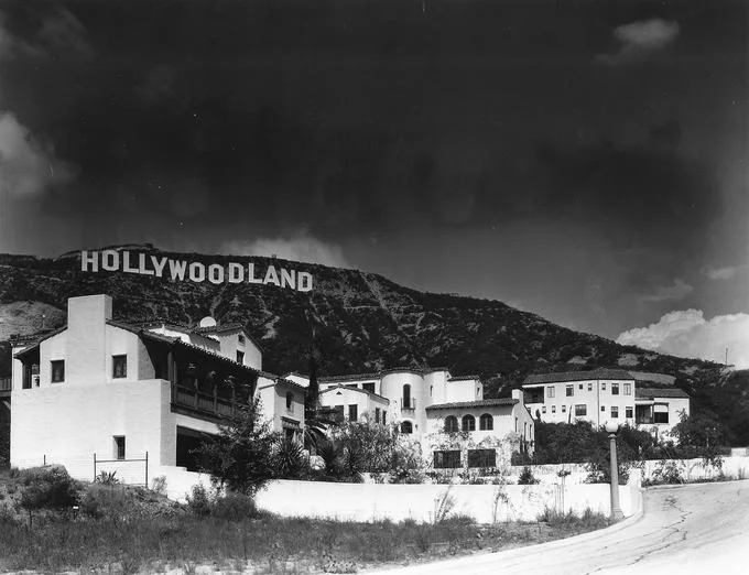 Hollywood Sign Parodies — Vintage black and white photo of the original HOLLYWOODLAND sign above 1920s houses