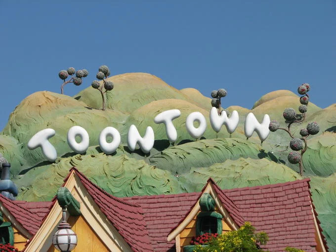 Hollywood Sign Parodies — Cartoonish TOONTOWN sign on green sculpted hills at Disneyland