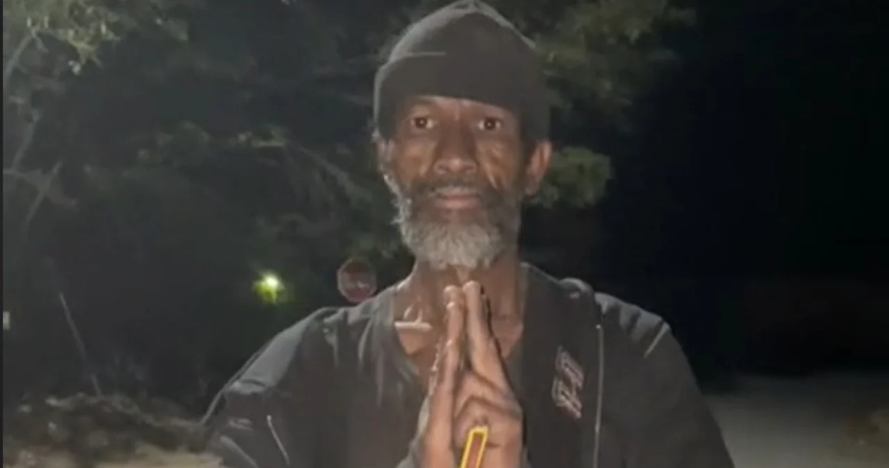 Homeless Man Doing Kung Fu — Bearded man in beanie holding hands in prayer gesture at night