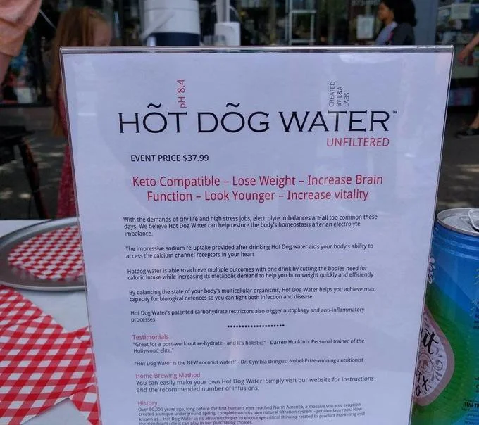 Hot Dog Water informational sign listing $37.99 price and satirical health benefits