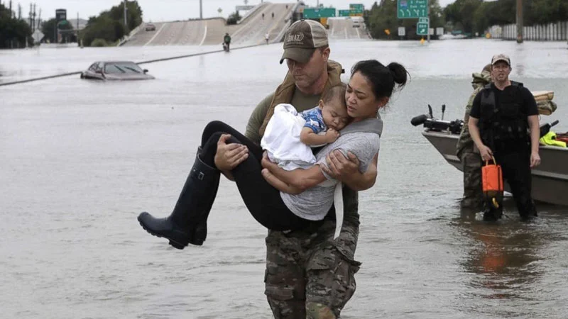 How It Ought To Be — Soldier carrying woman and baby through Houston flood waters during Hurricane Harvey