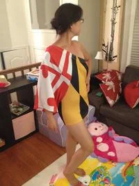 How To Make A Cute Dress Out Of Shorts — Person wears red and yellow shorts as dress in cluttered bedroom.