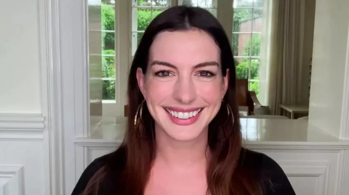 Anne Hathaway HR Meme — Anne Hathaway smiling during a Zoom video call in front of a sunlit window.