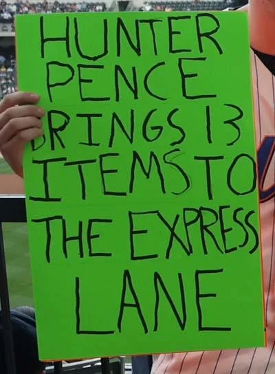 Hunter Pence Signs — Cropped photo of hands holding neon-green poster with 'Brings 13 Items To The Express Lane' text.