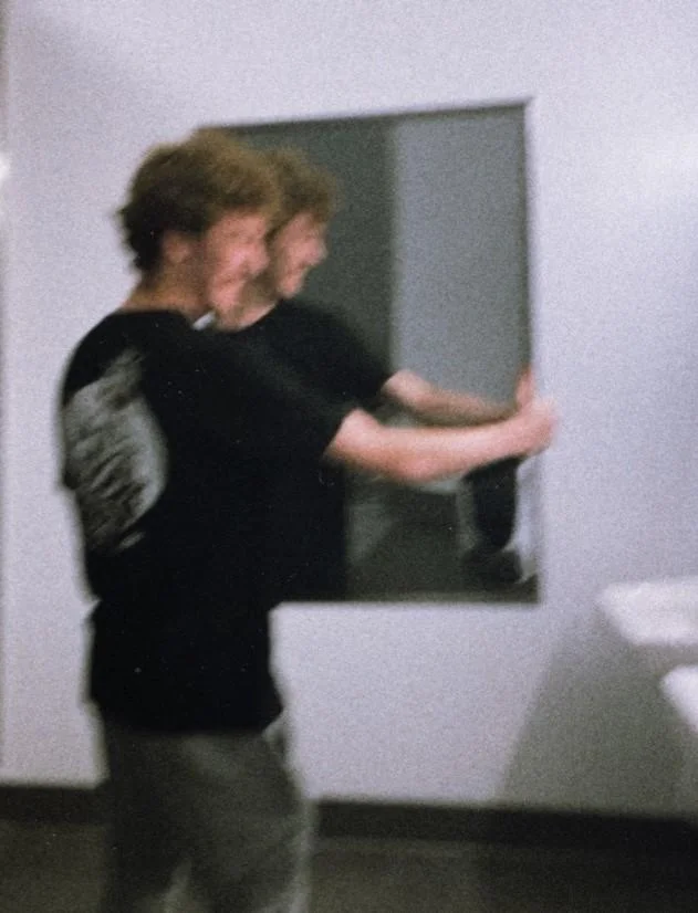 Hunter Schaffner and Holden Goyette Mirror Incident — Young man positioning a mirror on a bathroom wall with motion blur