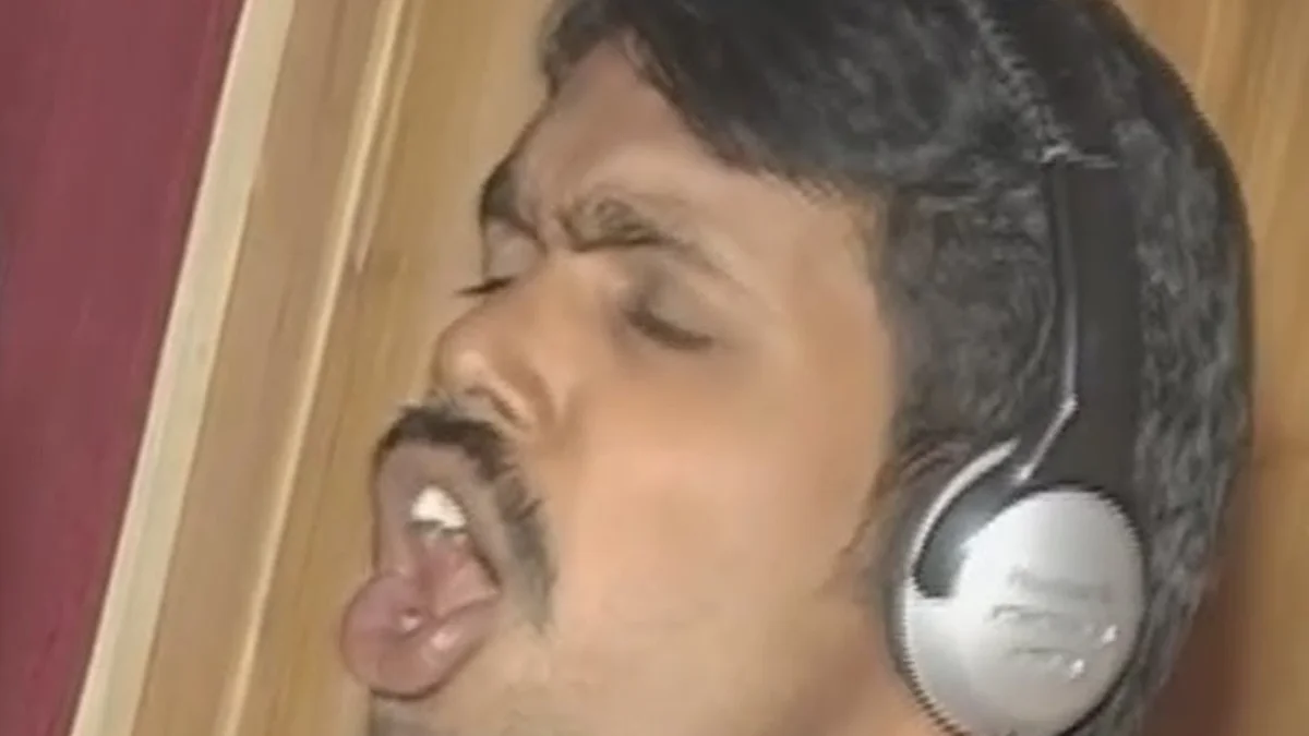 I Am A Very Good Bad Boy — Close-up of a man with headphones singing passionately with eyes closed in a studio
