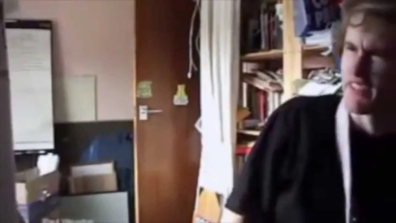 I Can't Believe You've Done This — Young man with pained grimace in a cluttered dorm room, moment after being punched