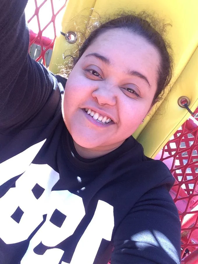 I Woke Up Like This — Smiling woman taking an outdoor selfie on a colourful playground.