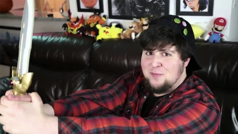 I'm a Brave Boy — JonTron holding a toy sword on a leather couch surrounded by plush toys