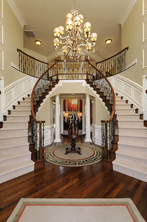 Inaccessible Foyer Landing — Traditional two-story foyer with symmetrical curved staircases and chandelier