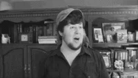 Internet Slang — Low-resolution black-and-white frame of man speaking or exclaiming from older video.