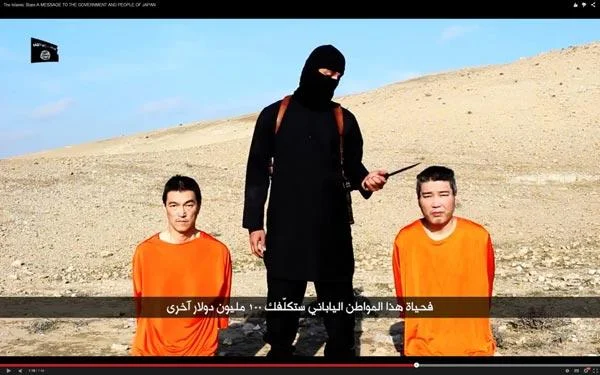 Isis Crappy Collage Grand Prix — Screenshot from 2015 ISIL propaganda video showing two Japanese hostages in orange jumpsuits with masked militant and Arabic