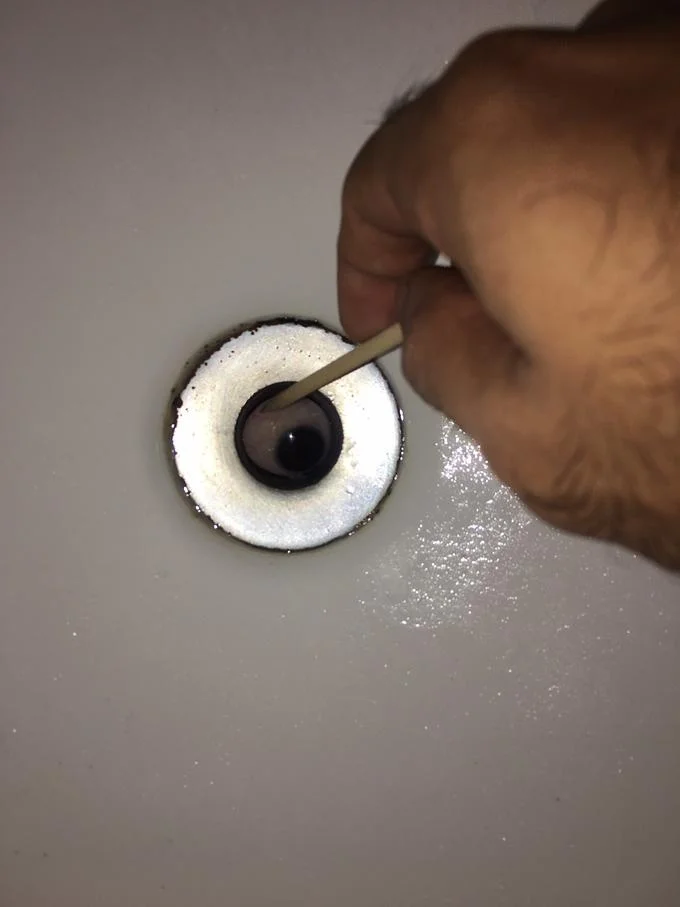 It Lives In My Sink — Hand poking a sink drain eyeball with a toothpick