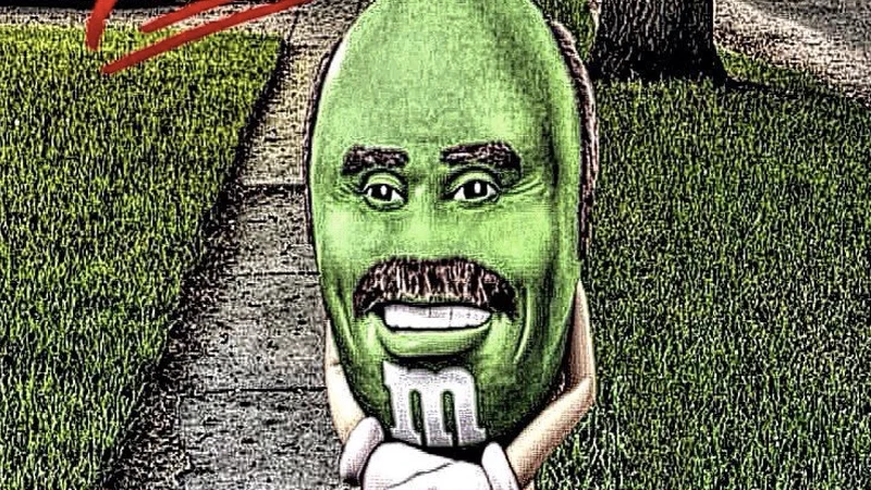It Really Do Be Like That Sometimes — Green M&M candy with Dr. Phil's face standing on a suburban sidewalk