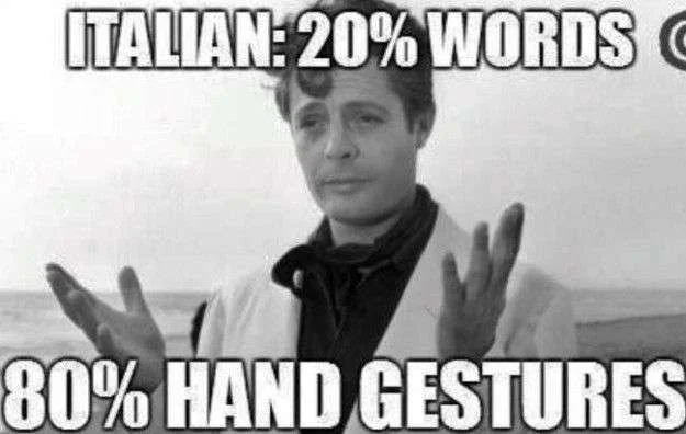 Italian hand — Black and white photograph of man with raised arms making expressive hand gestures with impact text about Italian communication ratio.